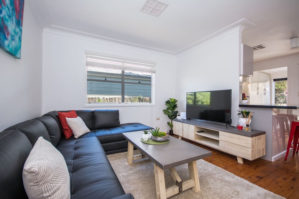 Living room with 49" TV, leather couch, super fast NBN internet (free) & free Netflix!