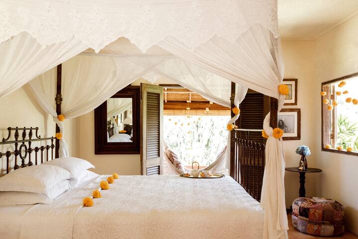 Bella卧室配备铸铁标准双人床（可设置2张床）、空调、吊扇、智能电视、套房卫生间和带花园景观的私人露台。