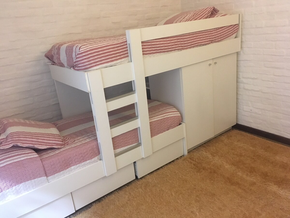 חדר שינה משני המצויד בשתי מיטות יחיד וטלוויזיה לקונסולות משחקים