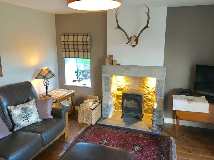 The new living room with wood burning stove & bright patio doors into the enclosed garden.