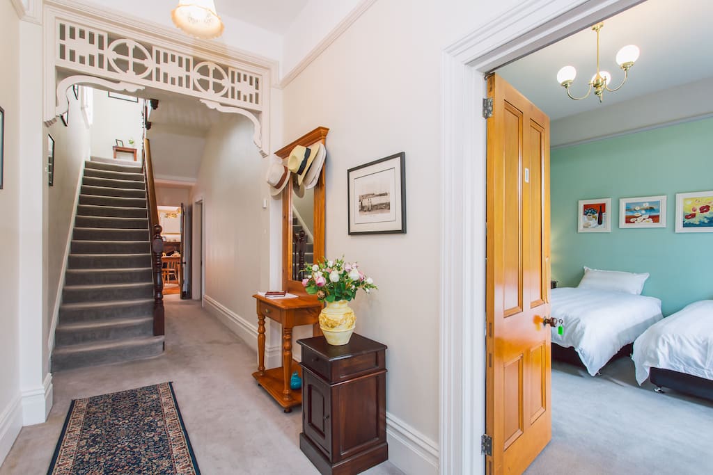 Downstairs hallway. Shared toilet is under the stairwell. Bedroom 2 is in the distance off to the right