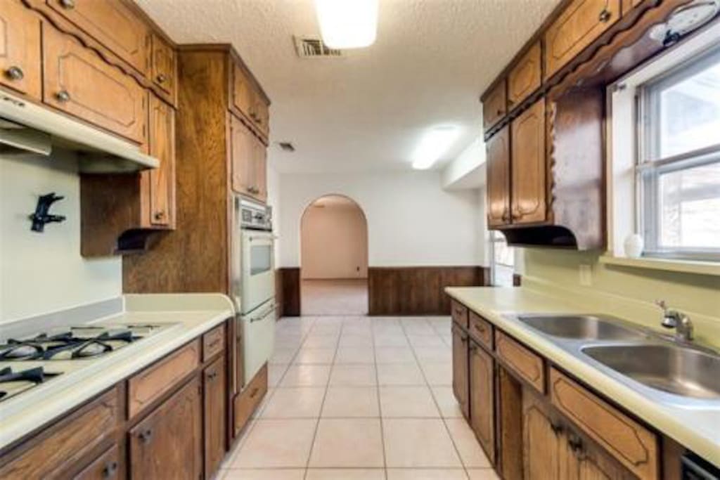 Large kitchen right off living room overlooking the backyard. Coffee pot, fridge, dishwasher, oven, broiler, has range and microwave.