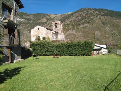 House with garden overlooking Romanesque church.