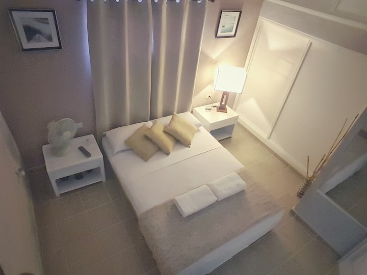 Dormitorio climatizado con cama matrimonial y una cama personal extra