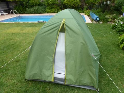 Tente dans un jardin de villa avec piscine.