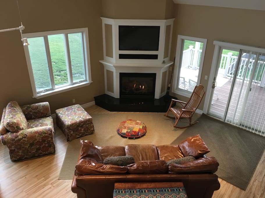 Living room with gas fireplace, smart tv, bluetooth speaker, and super comfy double chair and leather couch.