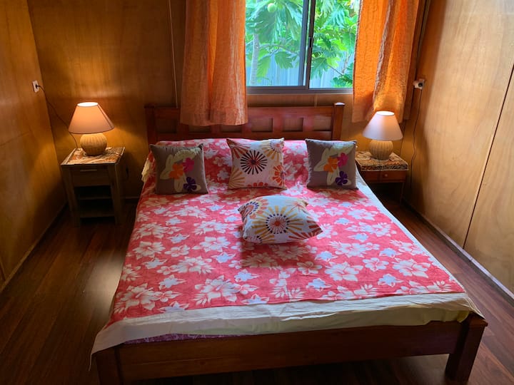Spálňa má manželskú posteľ, dva nočné stolíky s lampičkami, šatník a ventilátor