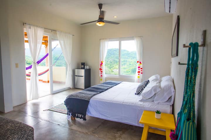 宽敞的卧室，自然光线充足，带滑动门，通往户外露台