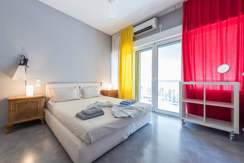 View of the bedroom with double bed, A/C, ceiling fan and access to the balcony!