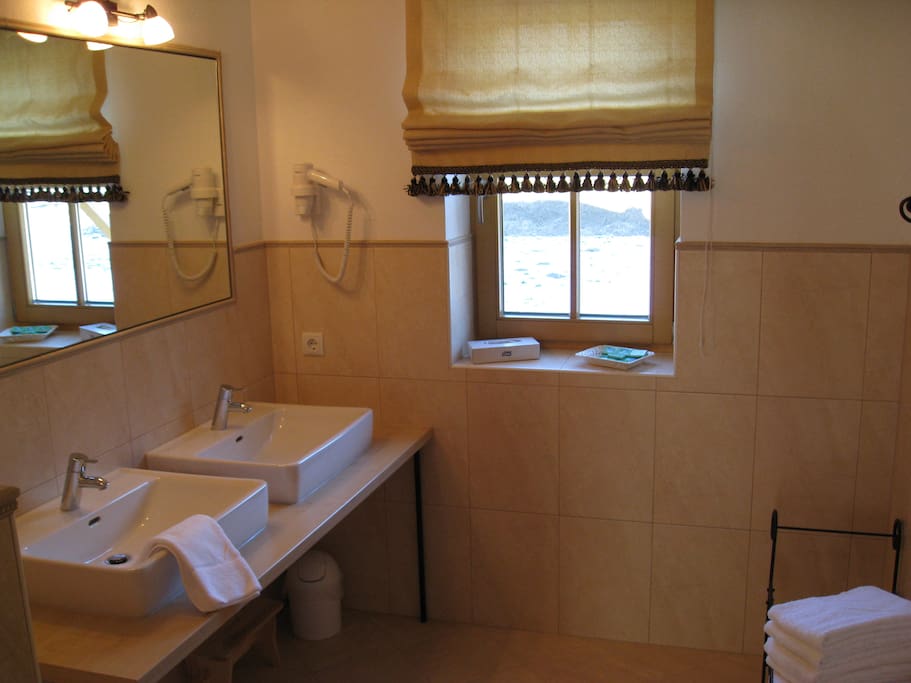 Badezimmer mit Doppelwaschbecken und Dusche. Toilette ist separat