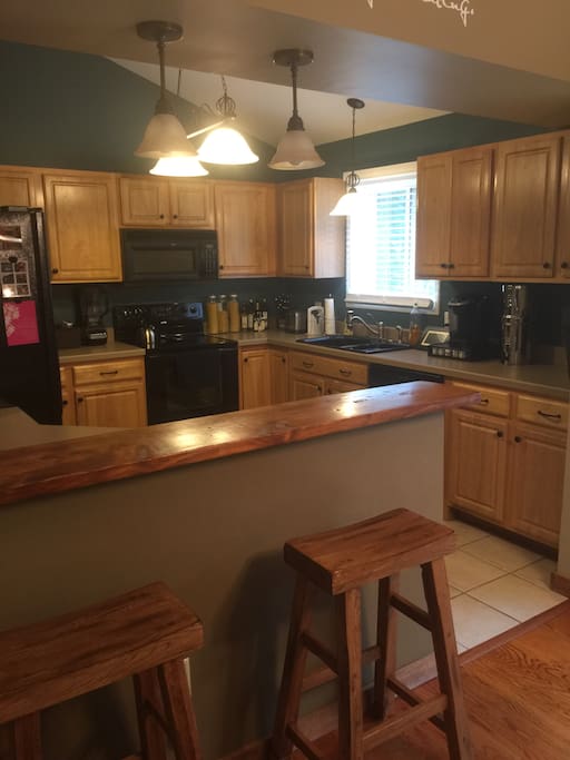 Large kitchen with breakfast bar, dishwasher, Keurig, and double door fridge.