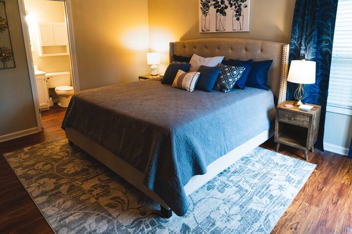 King size bed with attached bathroom and slider door leading to deck. 