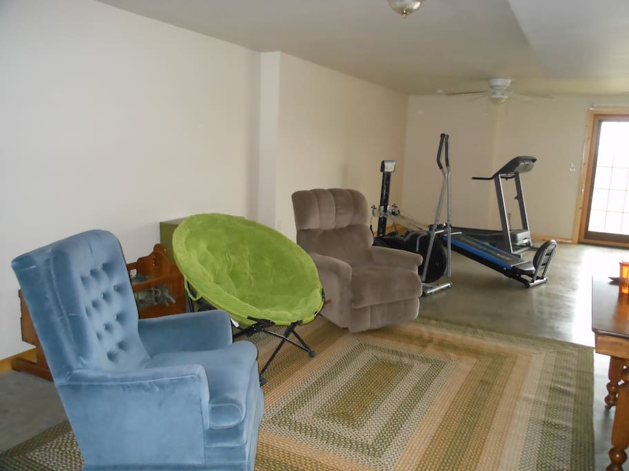Sitting area with treadmill and elliptical.