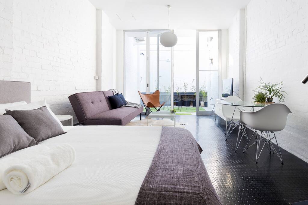 Rear Studio: Living Area - Queen size bed & outdoor courtyard beyond