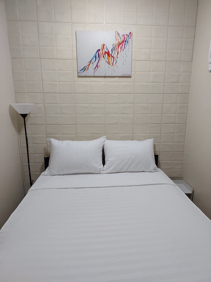 Kitanda chenye ukubwa kamili chenye meza ya pembeni na taa ya kusimama