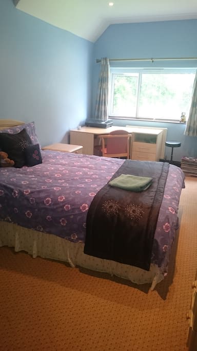 Large room with double bed and writing table