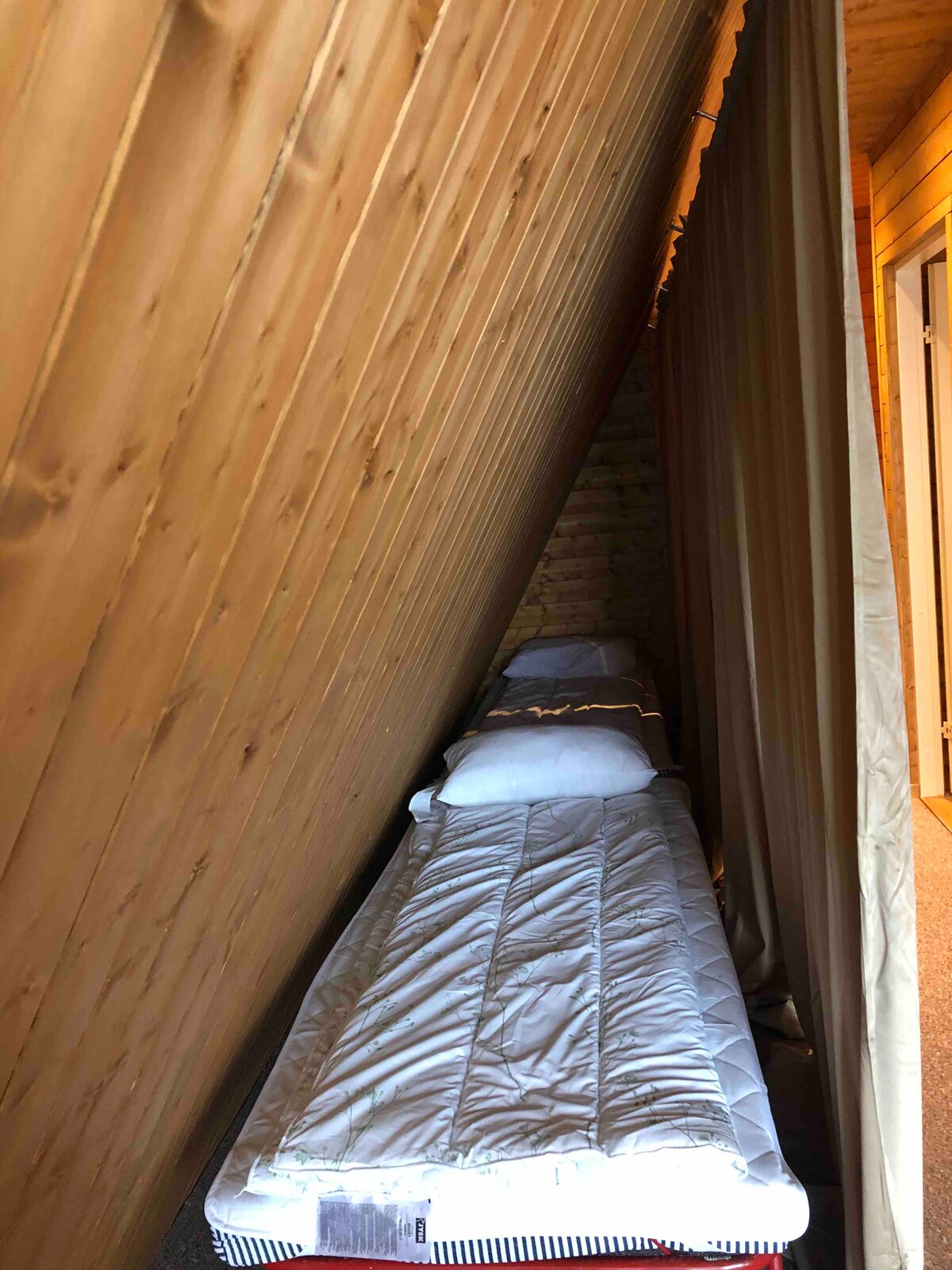 Alkov con dos camas individuales detrás de las cortinas 