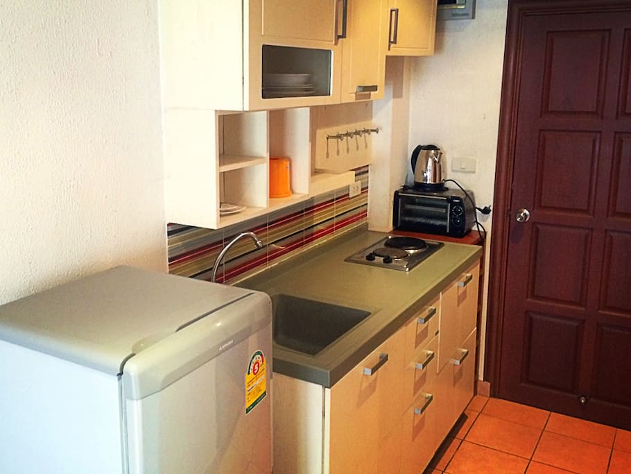 Kitchen with electric stove, fridge, and all needed kitchenware