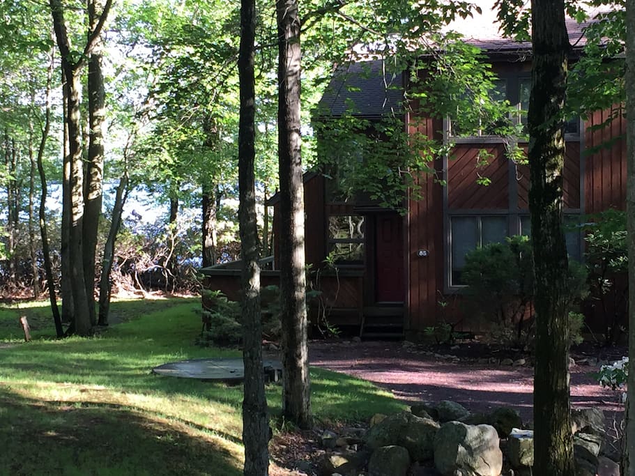 The end-unit townhouse is shaded by tall trees in summer.