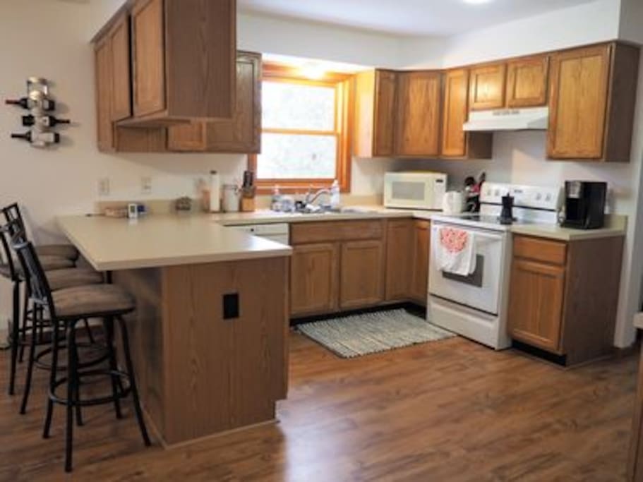 Fully equipped kitchen and breakfast bar with four stools.