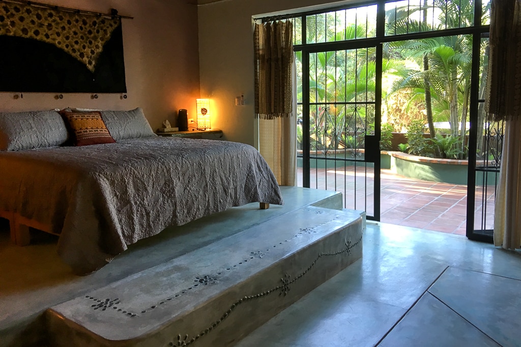 Në një fund të dhomës është krevati mbretëror në një platformë të ngritur me beton të lëmuar me guralecë dekorativë. Tarraca është jashtë. Shtrojat e krevatit janë të një cilësie të lartë dhe hapësira është plotësisht me ajër të kondicionuar