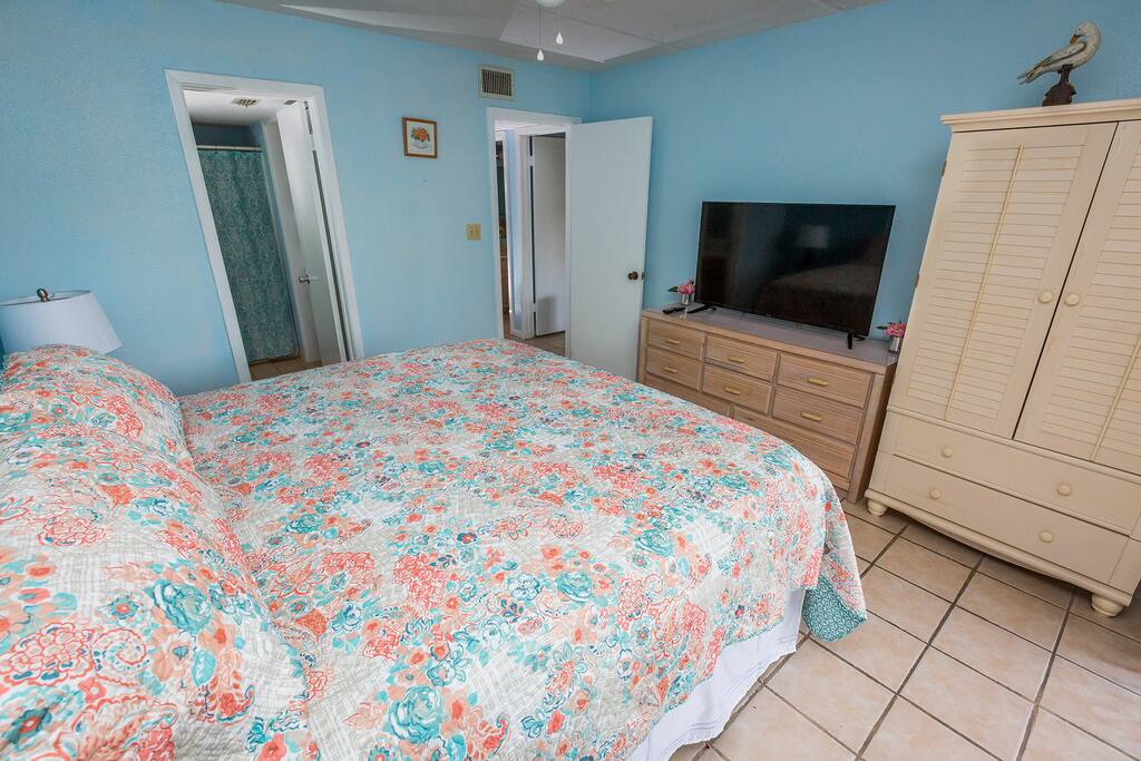 Master bedroom with a king-size bed and a 50-inch TV