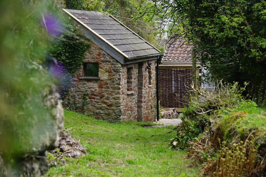The Byre is a single room stone building. A few steps away is the spa bathroom and behind is the private breakfast patio