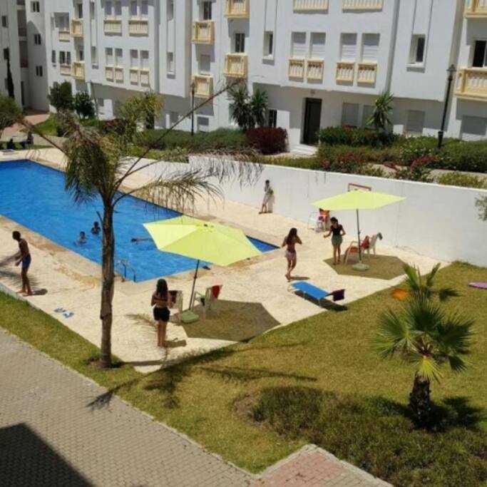 1 piscine et vue sur la porte d'entrée du building de l'appartement