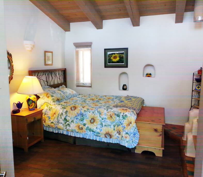 Skylight bright back master bedroom with queen-sized bed and direct view to patio and back yard.