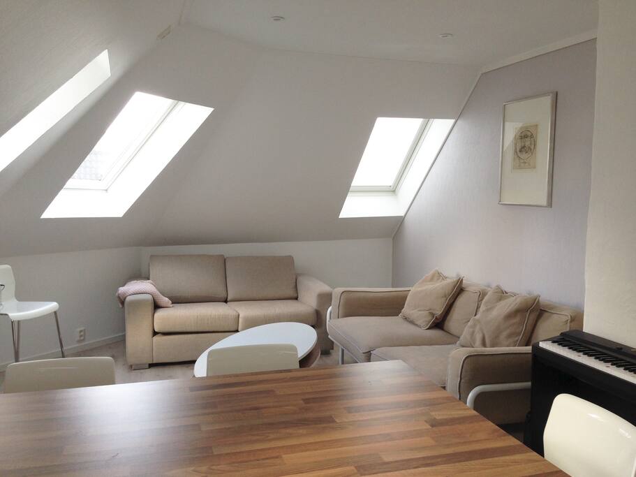 Livingroom with two comfortable couches and a keyboard. Here you can hangout, eat breakfast at the kitchen-bar, watch TV and generally have a good time.