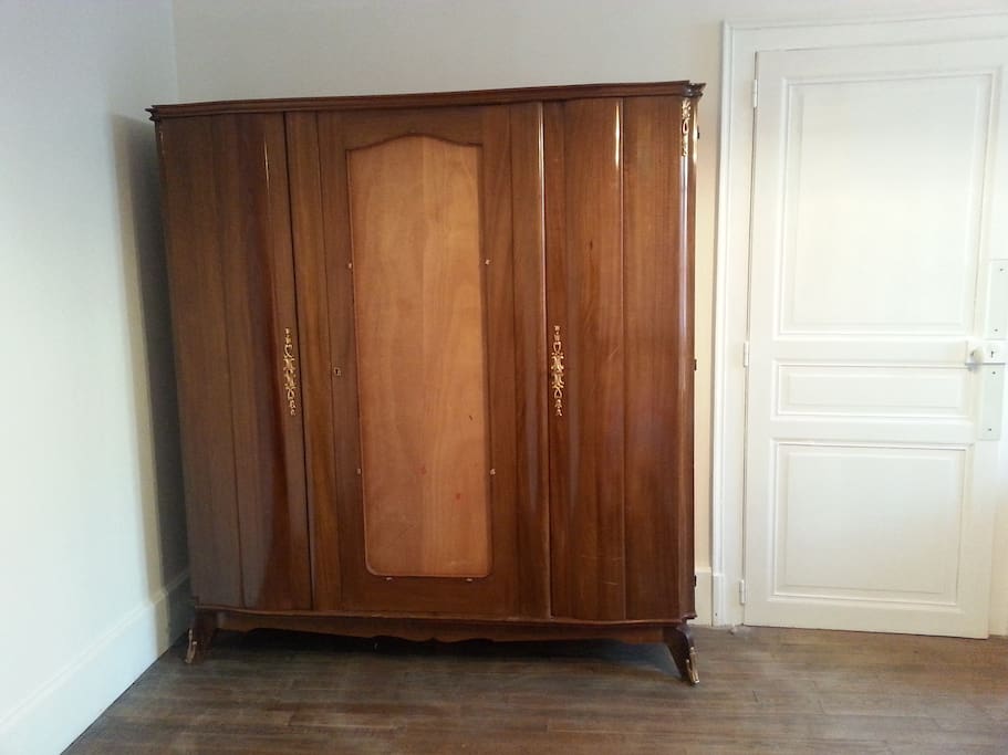 Une armoire avec étagères et penderie. Clé pour fermer votre chambre.