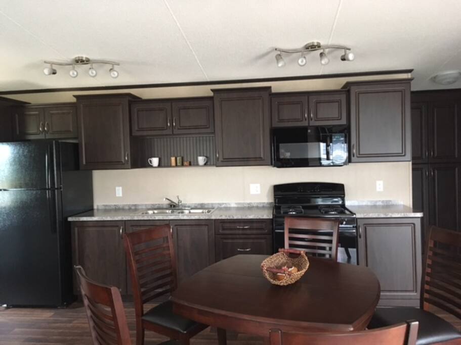 Modern kitchen stocked with dishes/pots/pans/utensils and basic pantry items