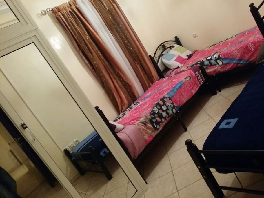 Une chambre pouvant accueillir plusieurs couchages avec des espaces de rangement et de vie