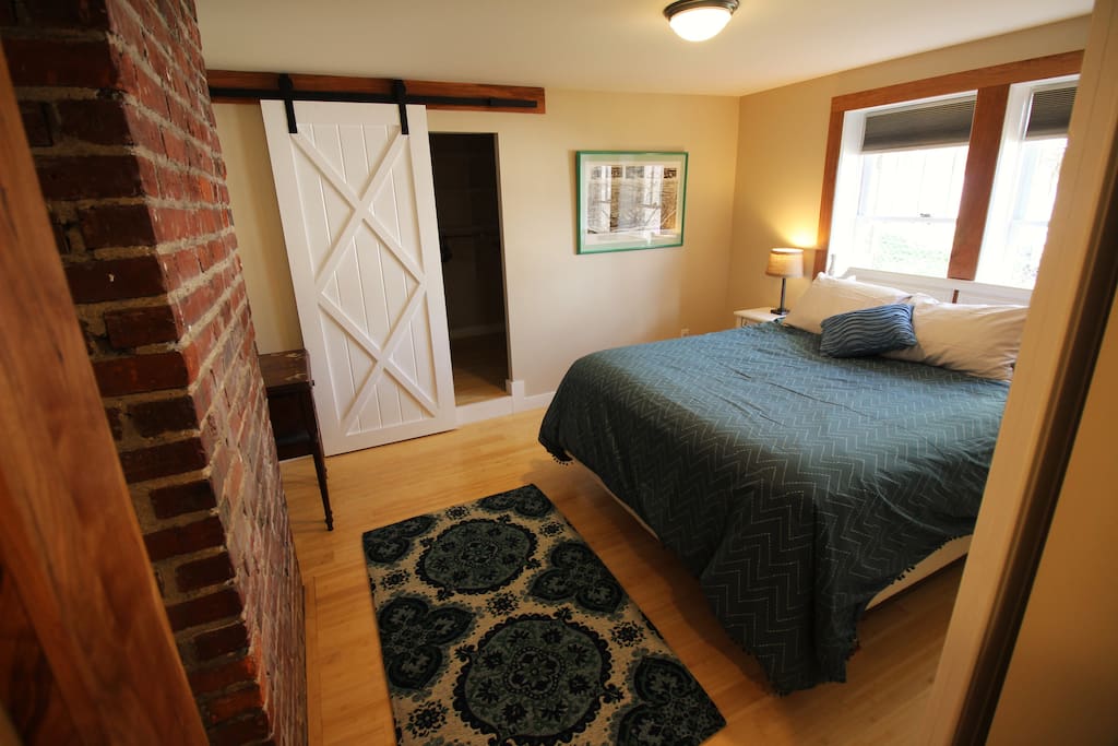 Bedroom has barn doors and exposed brick