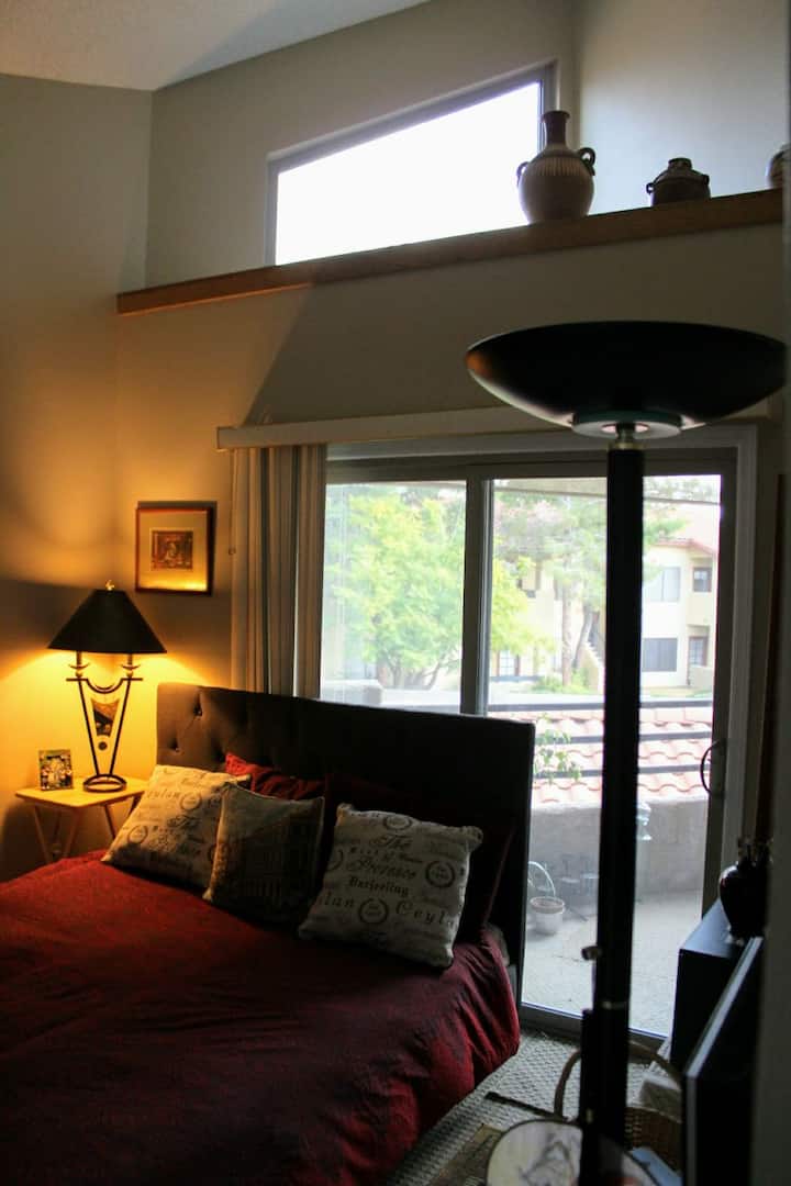 Уютна спалня за гости с изглед към балкона.