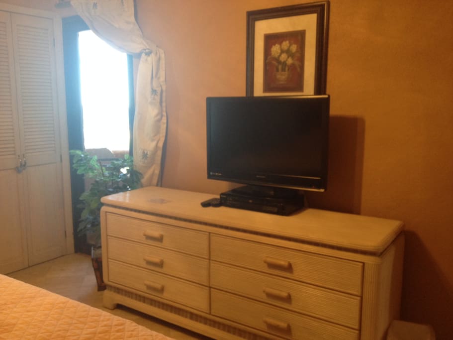 Master, TV and dresser, with ocean view and entrance to patio.