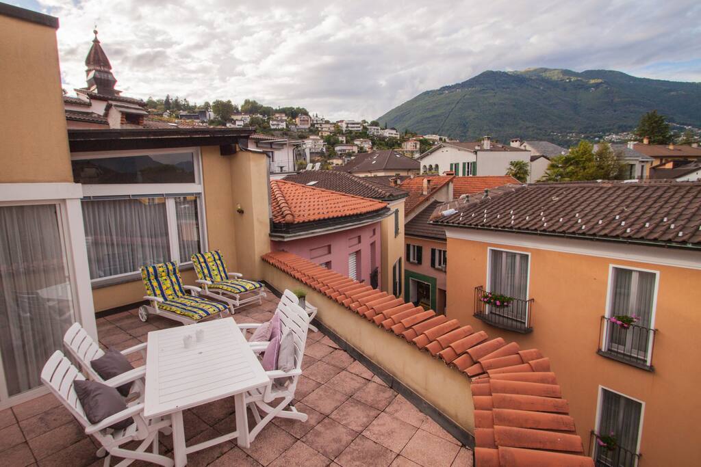 Dachterrasse mit Tisch und Liegestühlen