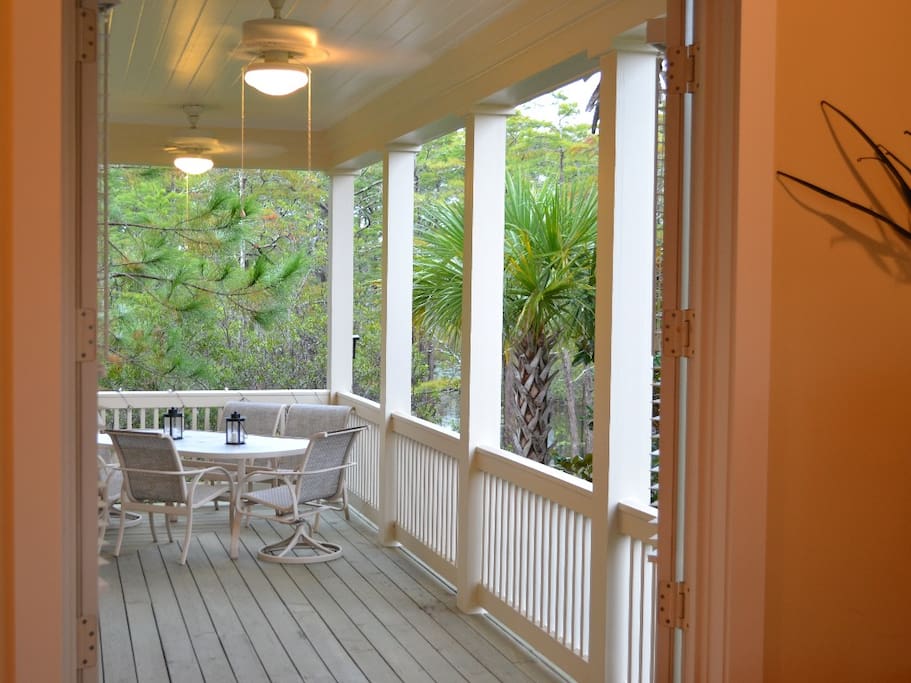 Wraparound side/back porch features hammock overlooking blackwater cypress pond, space for outdoor dining