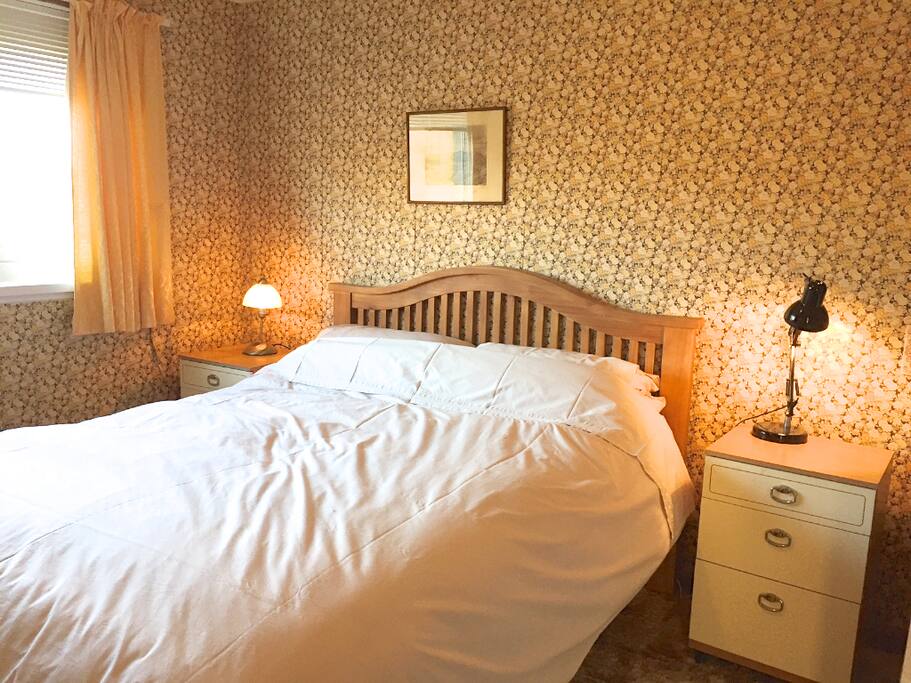 Bedroom with kings size bed, wash hand basin and built in wardrobes.