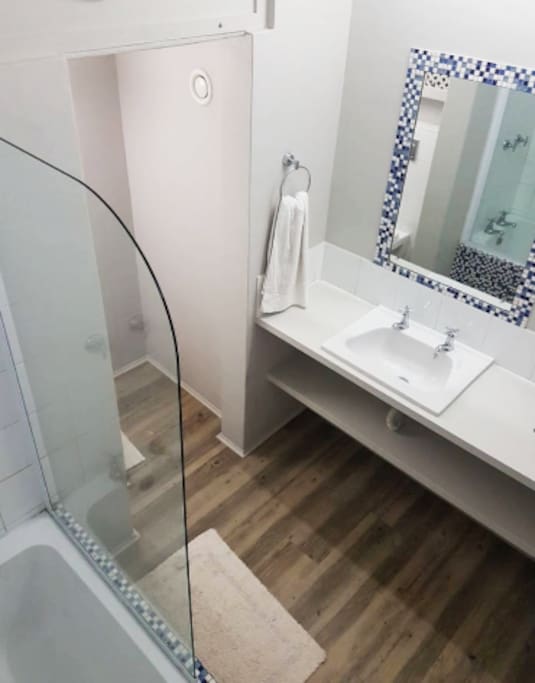 Contemporary simplicity bathroom for a good clean look - has a shower/bath combo, toilet, sink, and loads of counter space.