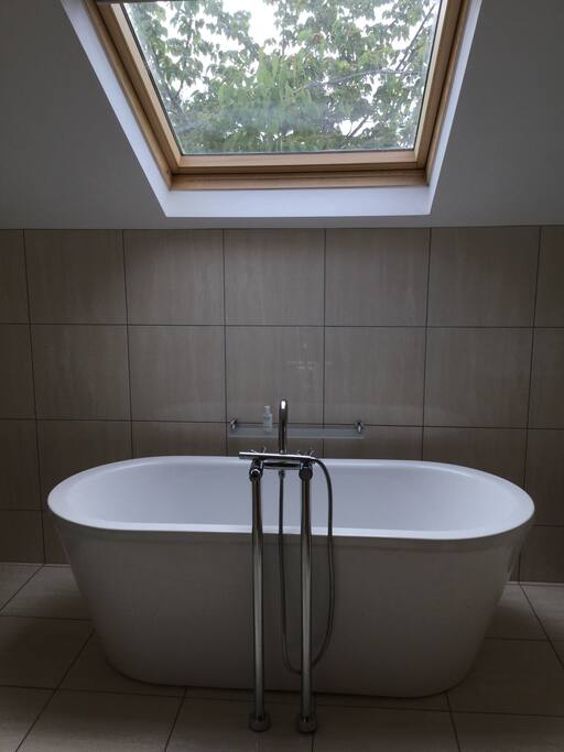 One bathroom with bath as well as showers