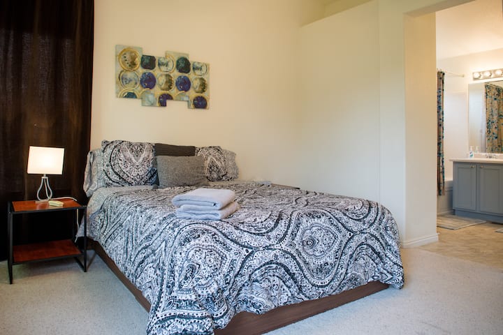 Chumba kikubwa cha kulala kilicho na mapazia meusi na bafu iliyoambatanishwa