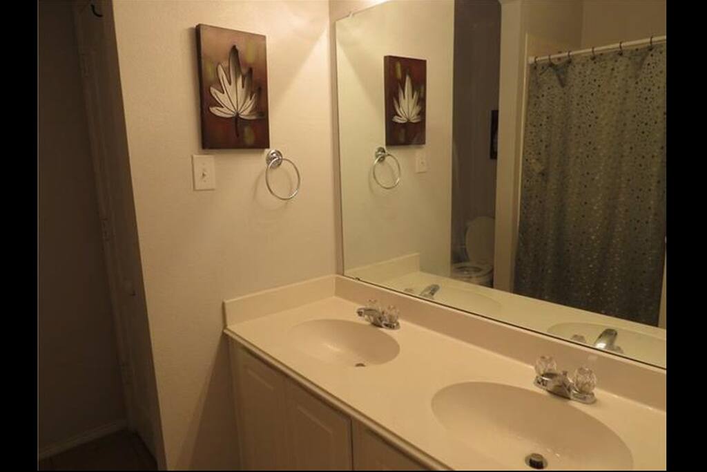 Guest bathroom. 2 sinks, toilet, shower.