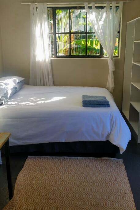 A comfortable Queen sized bed with clean linen and towels and a good sized cupboard. The North facing window overlooks the private back garden and gets dappled morning sunlight. More storage space is available for bags and suitcases in the laundry room, which is in the back garden.