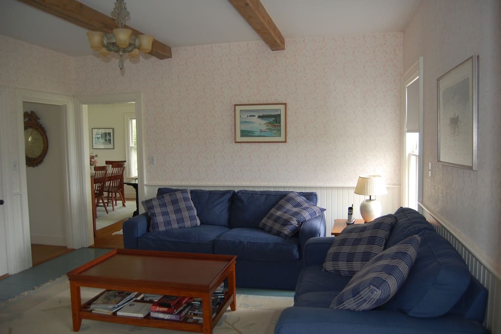 Family room, two comfortable couches and coffee table. View to living and dining room beyond.