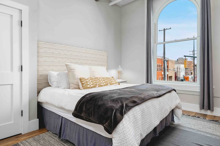 Este segundo dormitorio generoso cuenta con ventanas altas a lo largo de Cass St. Para disfrutar de una vista del horizonte en todo el centro de Traverse City.