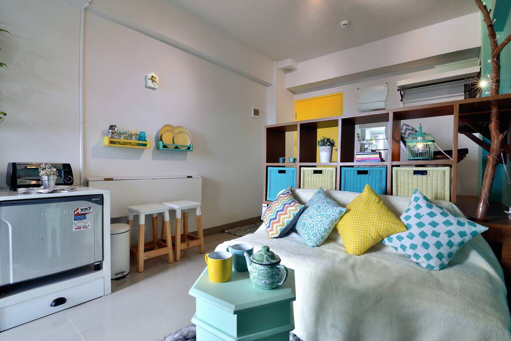 Queen sized bed disguised as a sofa for relaxing in day time, dining table folded to the wall to save space when not used