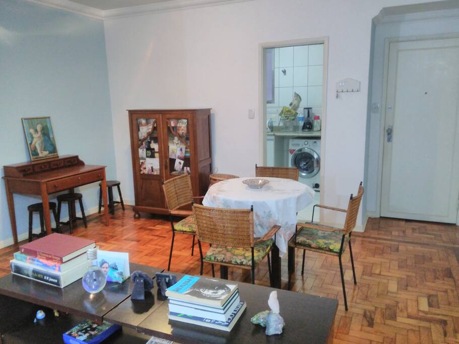 Sala de estar compartilhada com mesa para refeiçoes e escrivaninha..