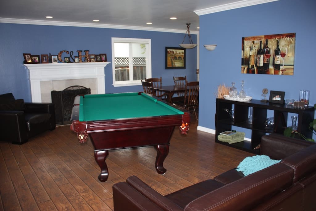 Living room, pool table, fire place, dining room.