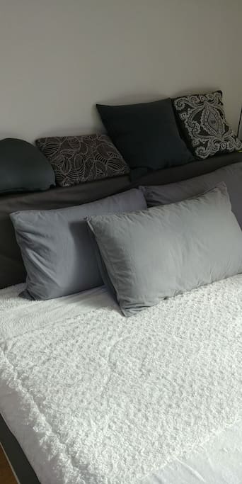 A king size bed with many pillows